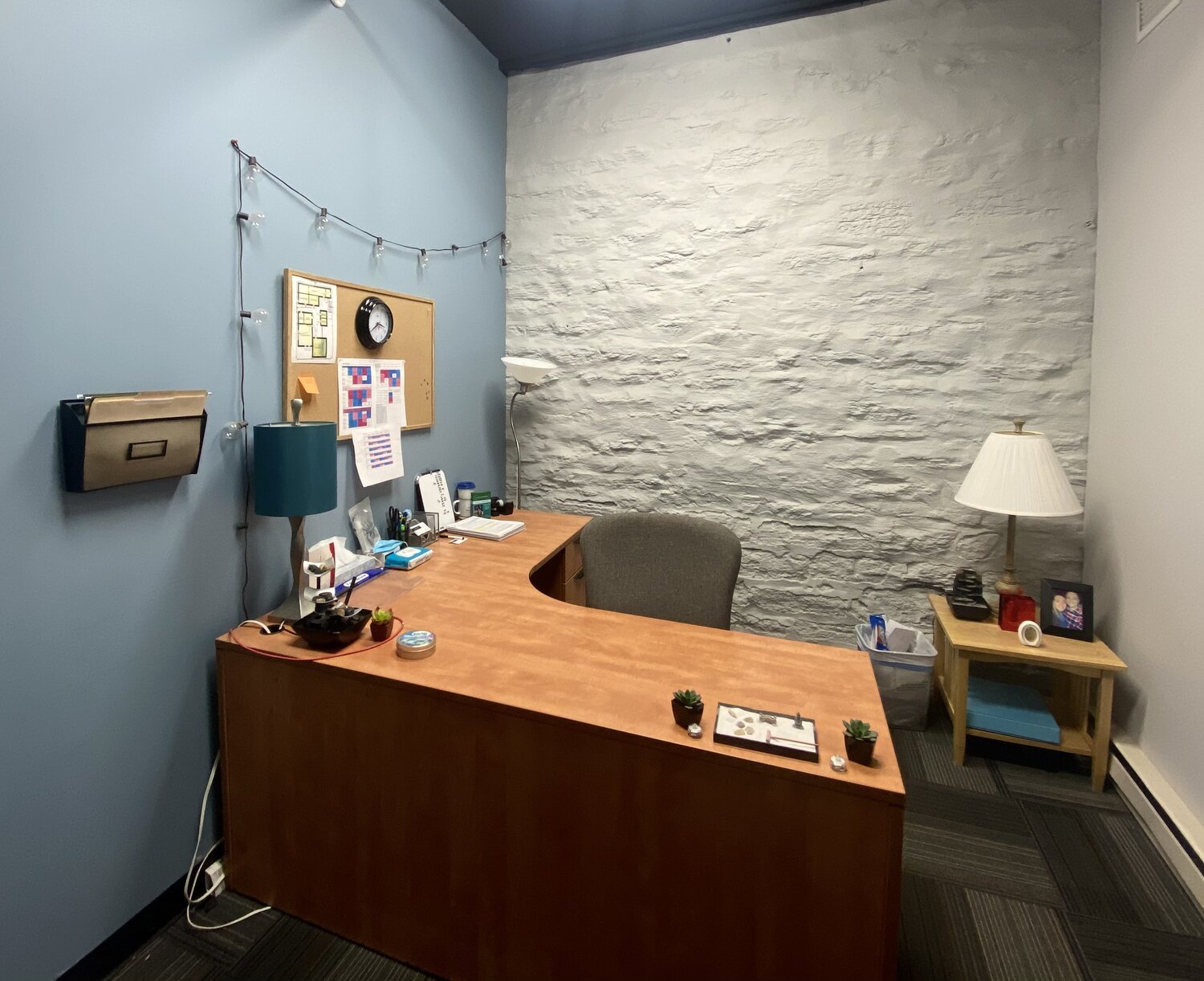 Private counseling office with L-shaped desk and soft lighting