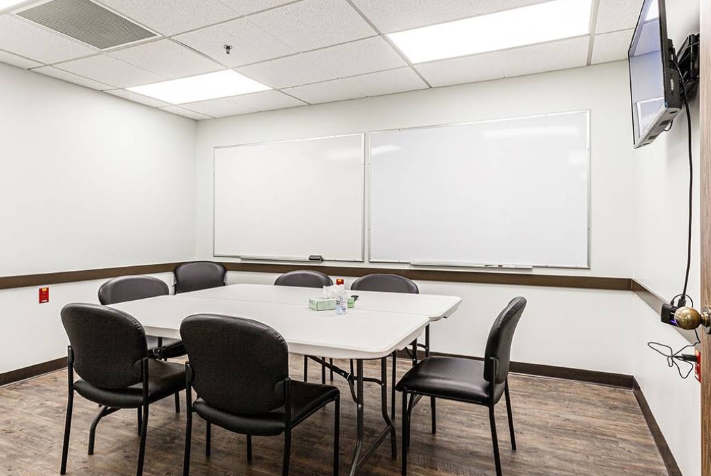 Small room with table, chairs, and whiteboards