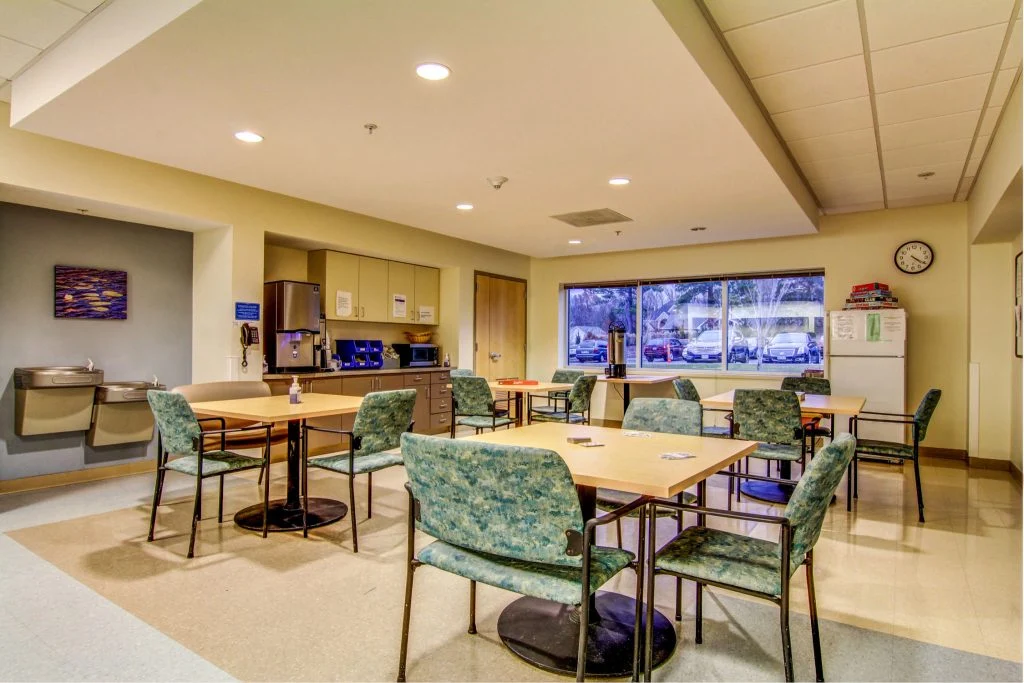 Dining hall with tables, chairs, and beverage station.