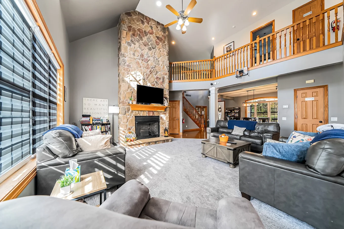 Spacious living room with sofas, fireplace, and vaulted ceiling