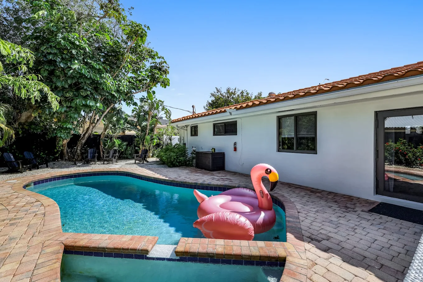 Outdoor swimming pool with attached spa and patio