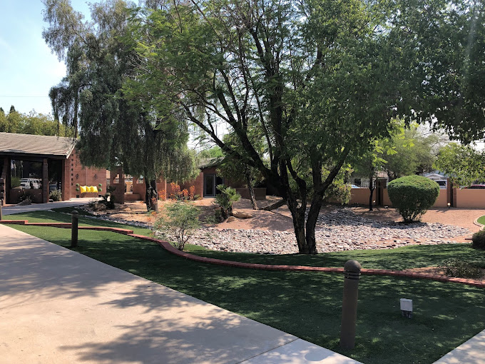 Contemporary facility exterior with trees and lanscaped walkway.
