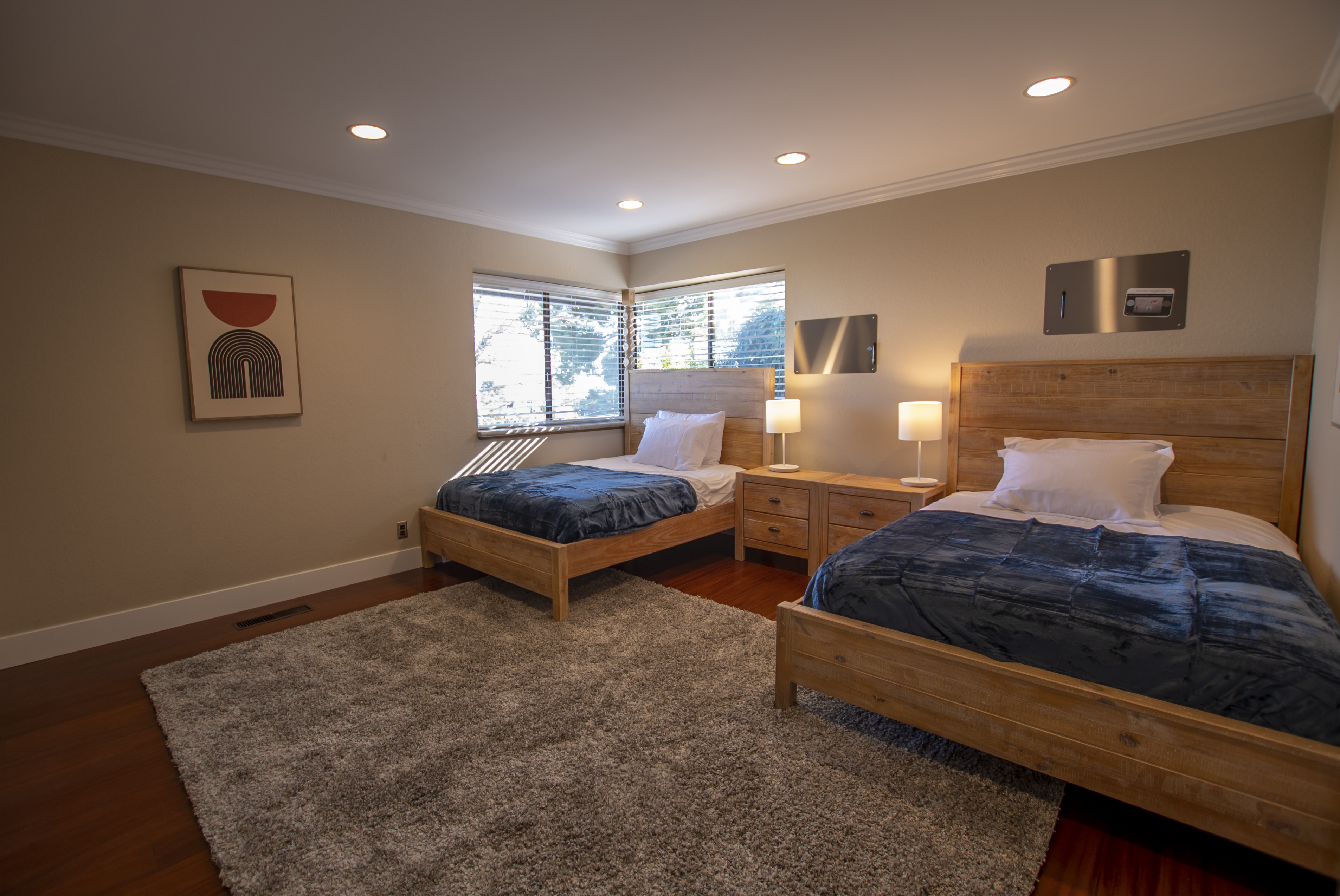 Twin beds with blue throws in softly lit bedroom