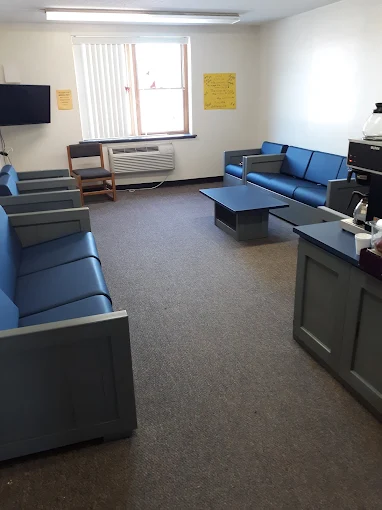 Lounge with blue sofas, coffee table, and TV
