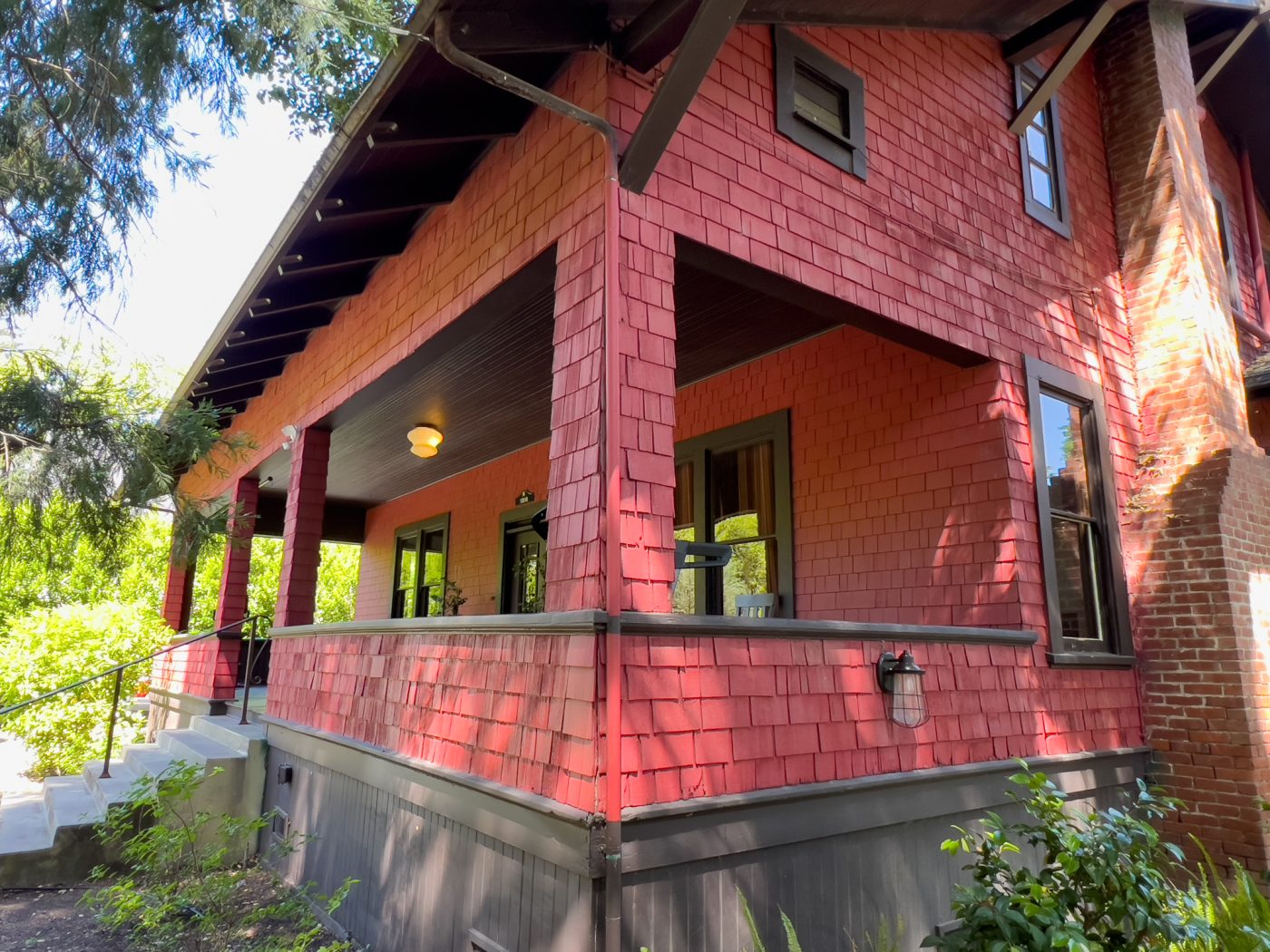 Red house exterior with covered porch and steps