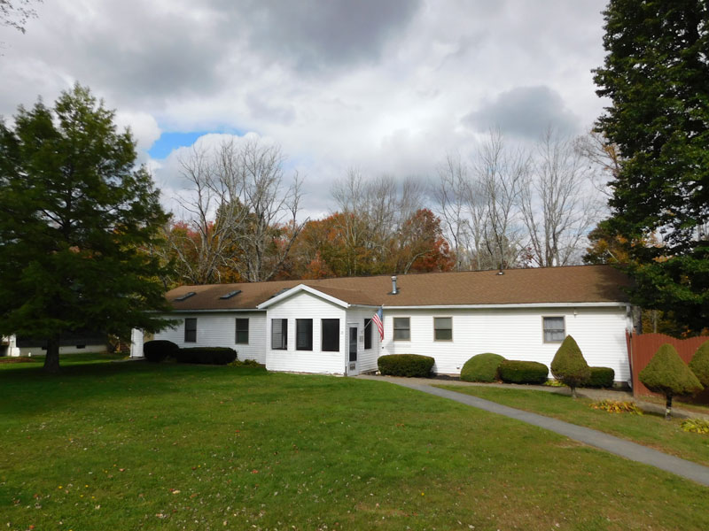 Single-story residence with lawn and surrounding trees