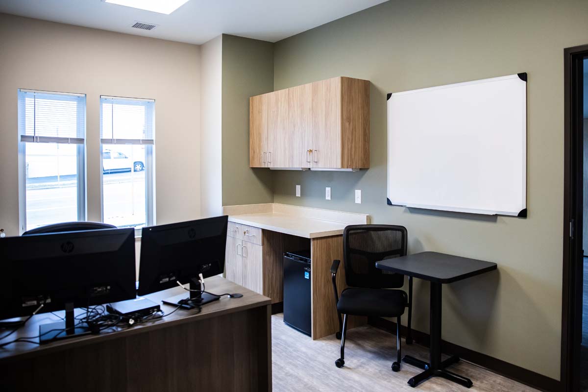 Office with desk, cabinets, whiteboard, and two computer monitors
