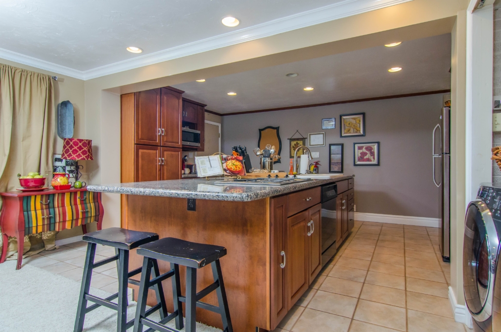 Granite island kitchen with seating and cooktop