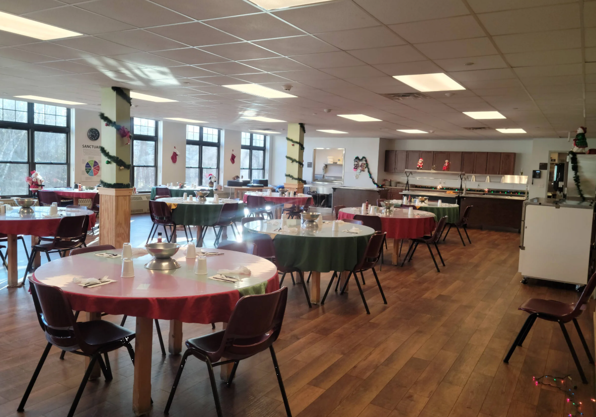 Dining hall with round tables set for shared meals