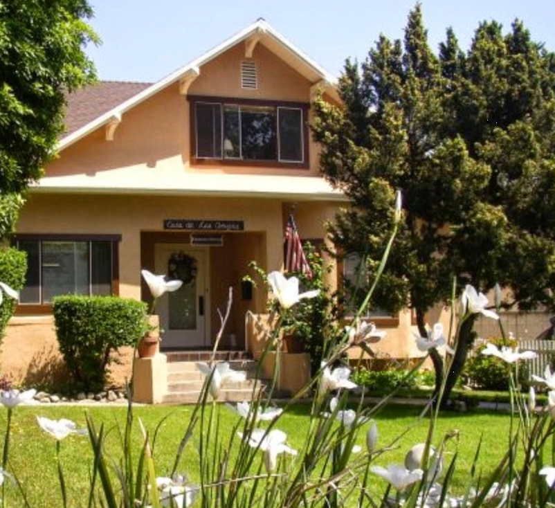 Sunny exterior of Casa Treatment Center with garden flowers