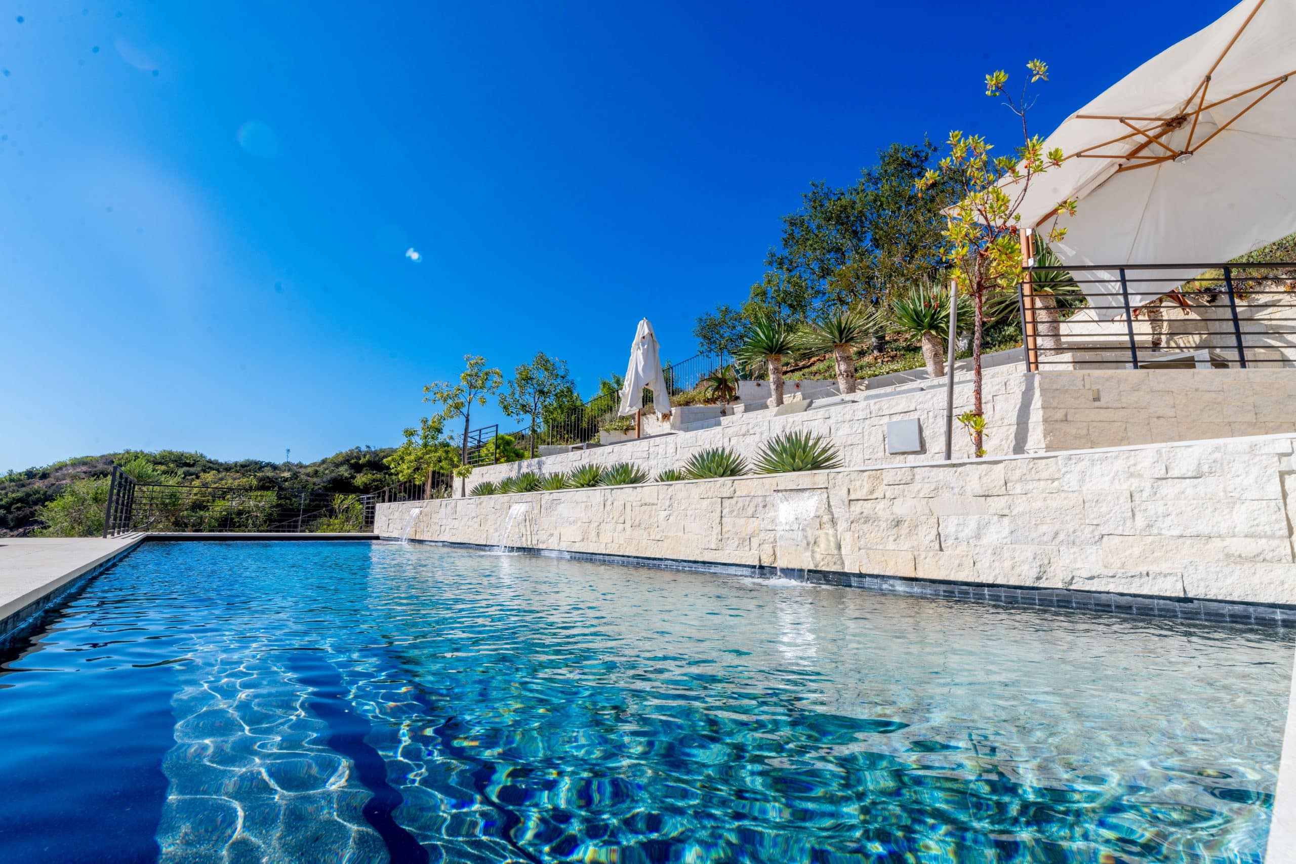 Outdoor swimming pool with hillside landscaping and seating