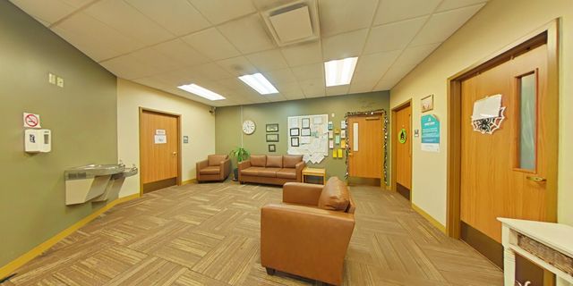 Lobby with brown chairs and hallway access
