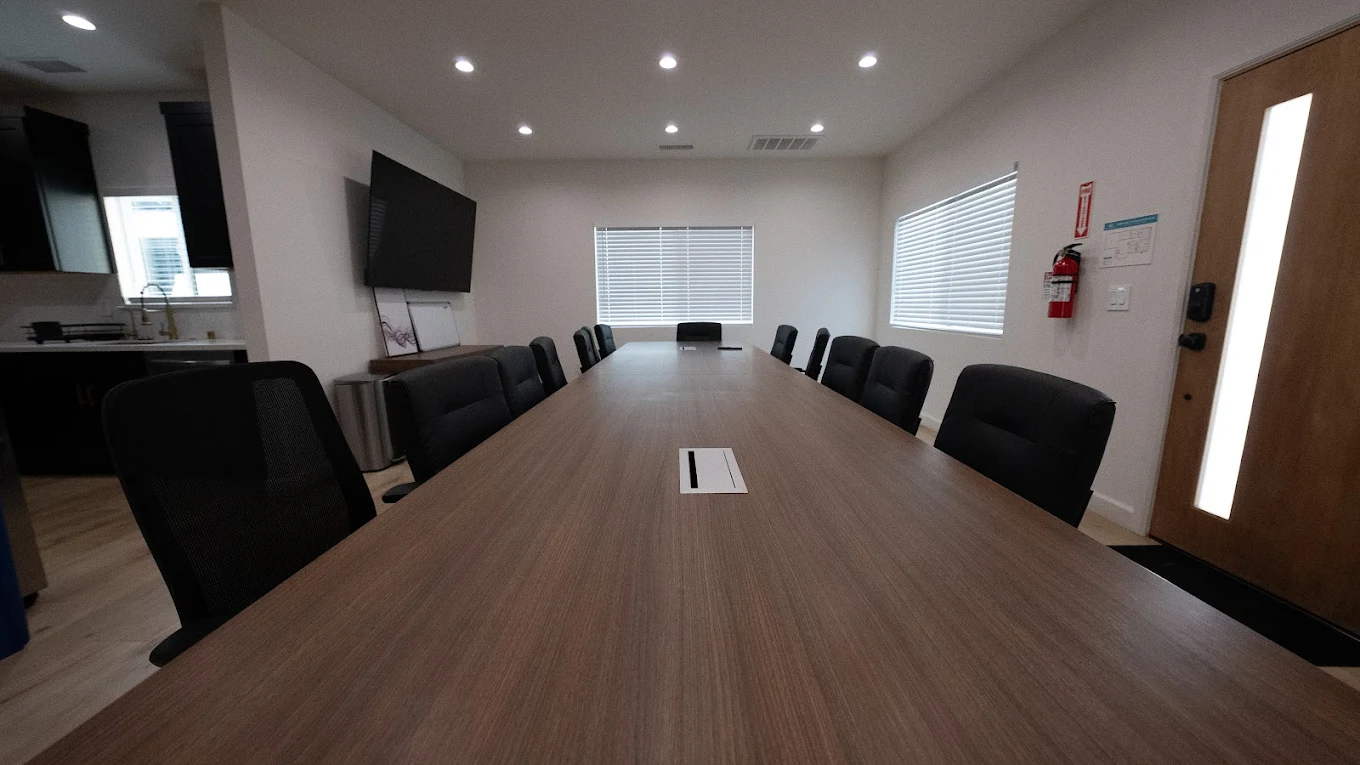 Conference table with chairs and wall-mounted TV