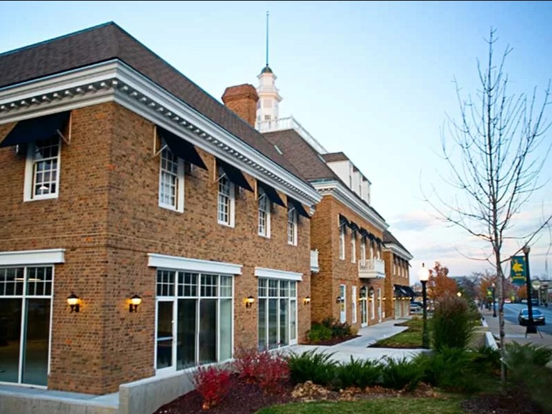 Side view of brick facility along sidewalk and landscaping