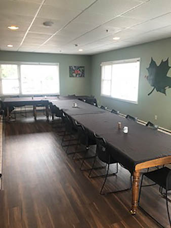 Dining room with long tables and chairs for group meals.