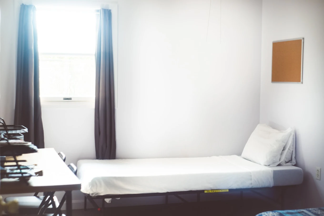 Simple shared bedroom with single bed and natural light