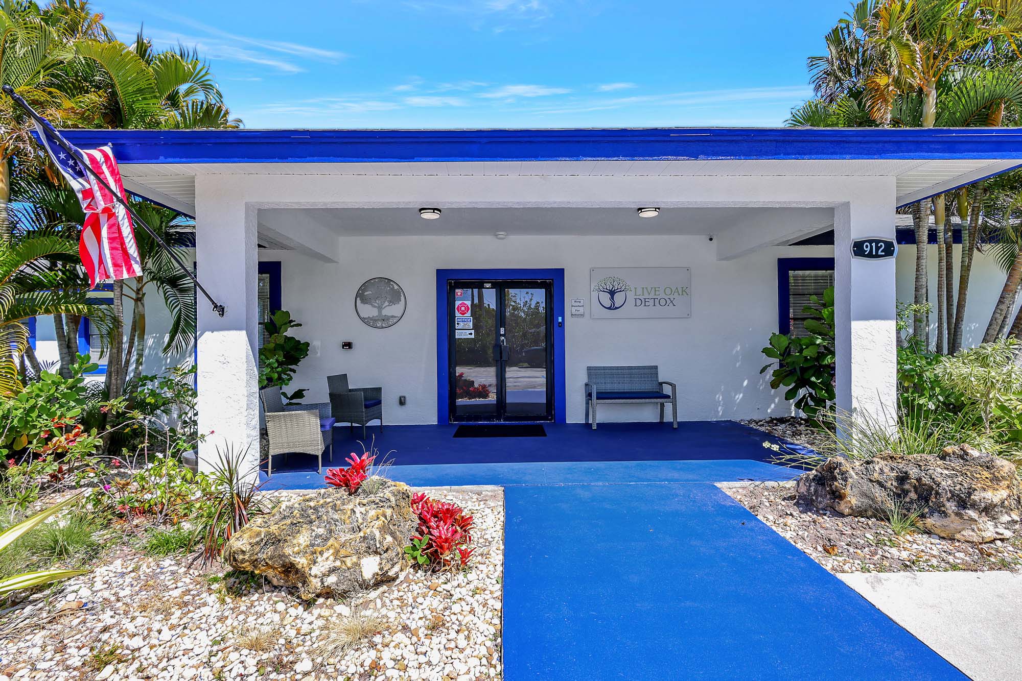 Exterior entrance with blue trim and outdoor seating