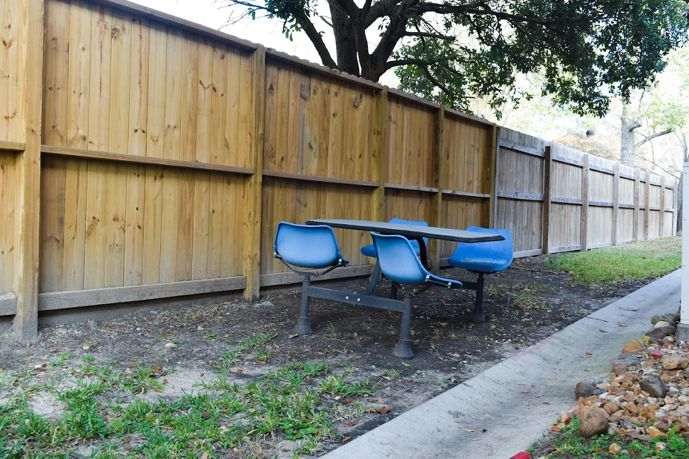 Blue bench-style seating next to a wooden privacy fence
