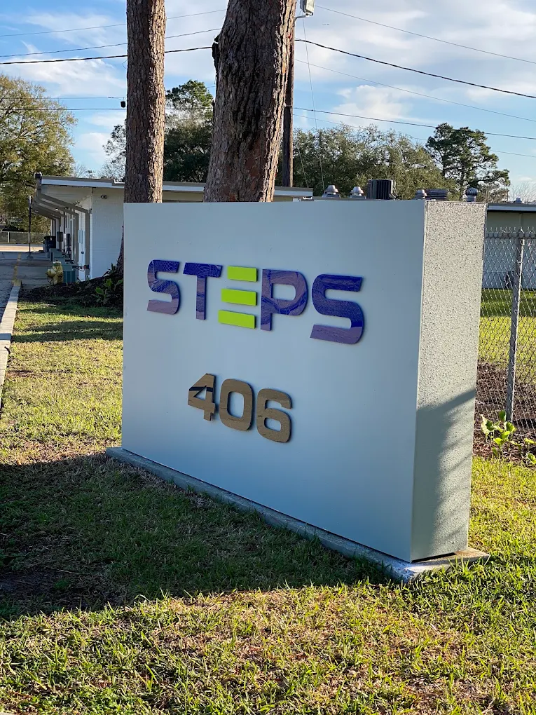 Outdoor Steps 406 sign positioned near the recovery facility grounds