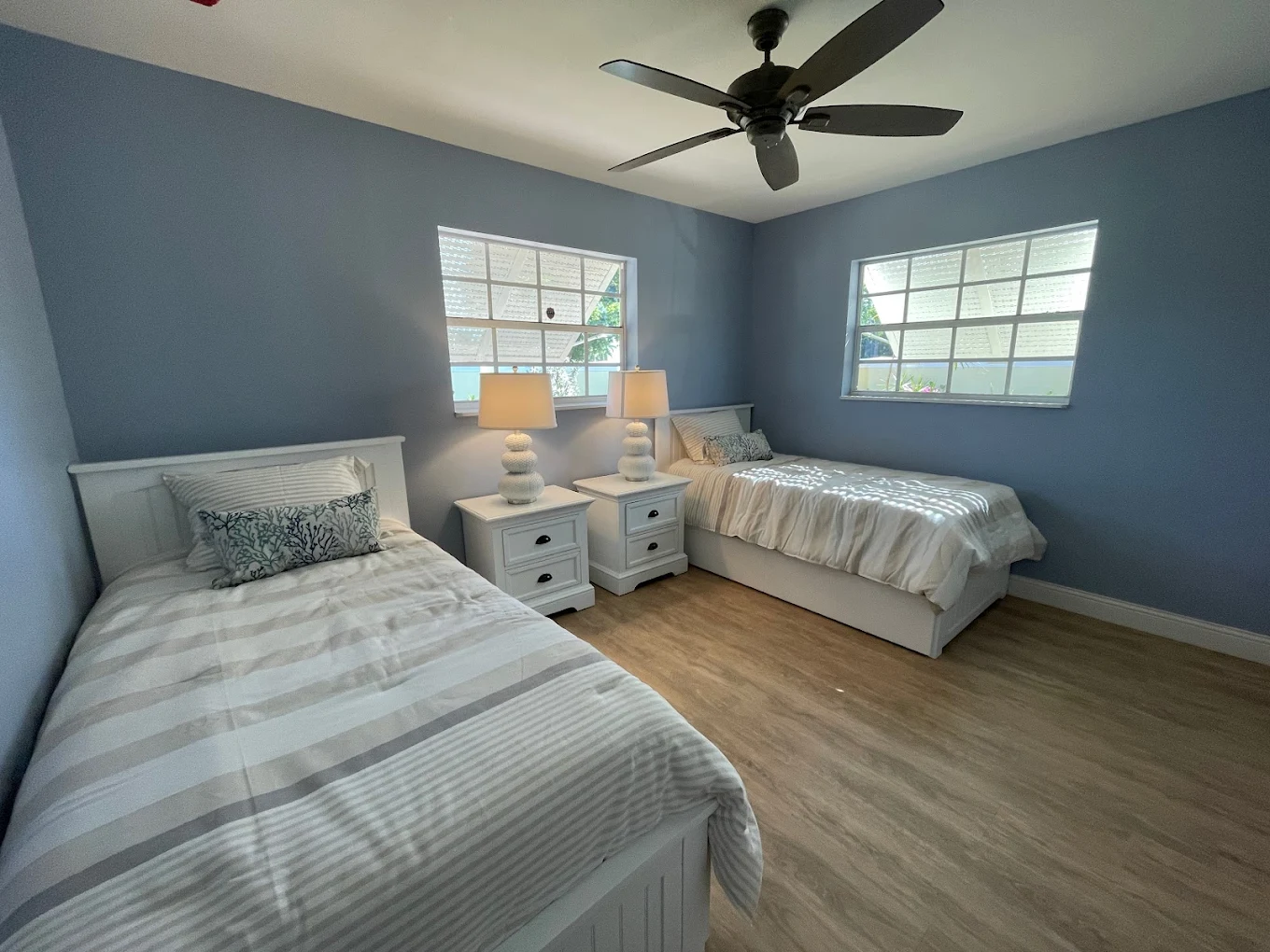 Twin beds with white bedding in bright blue room