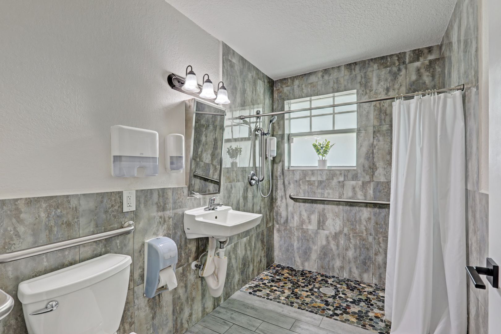 Accessible bathroom with walk-in shower and safety rails
