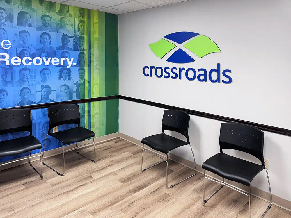 Chairs along wall with Crossroads logo and recovery mural