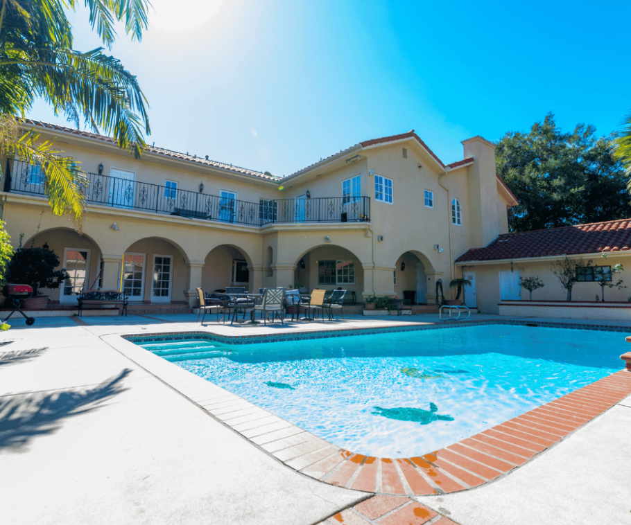 Outdoor pool with seating and two-story facility backdrop