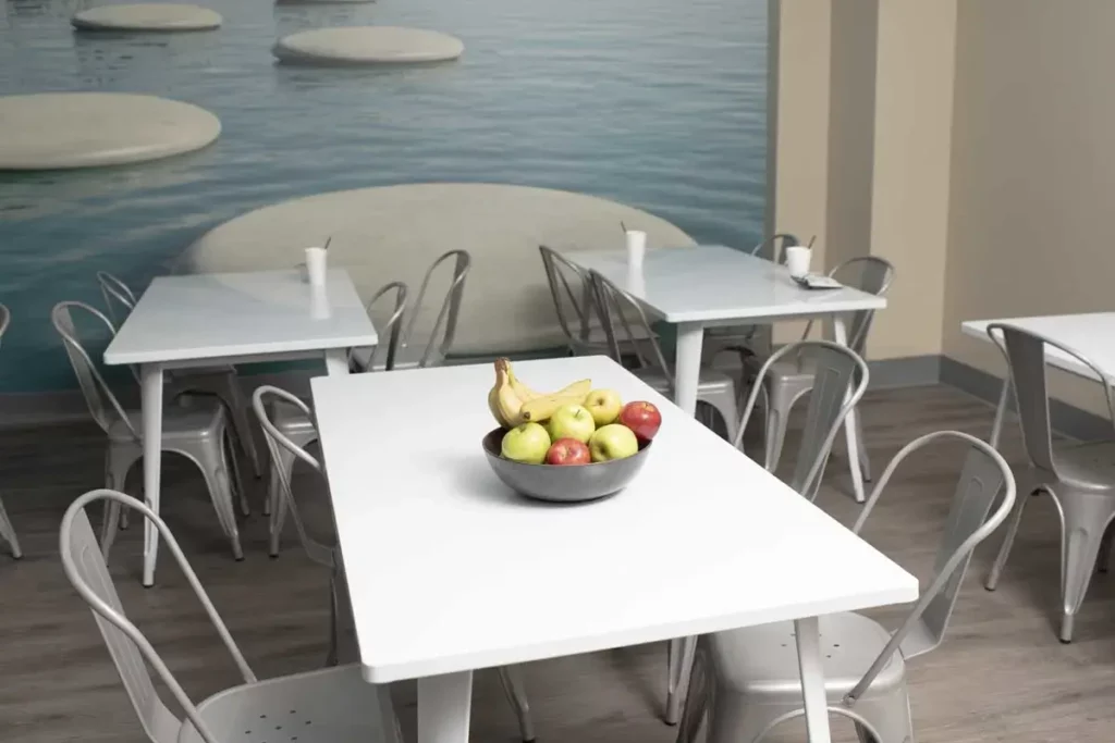 Modern dining area with white tables and fruit centerpiece