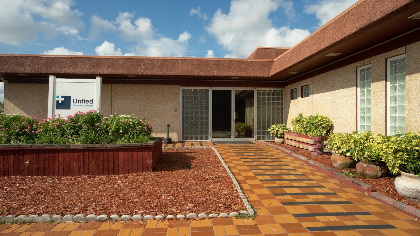 Facility exterior with signage, brick walkway and landscaping to entrance.