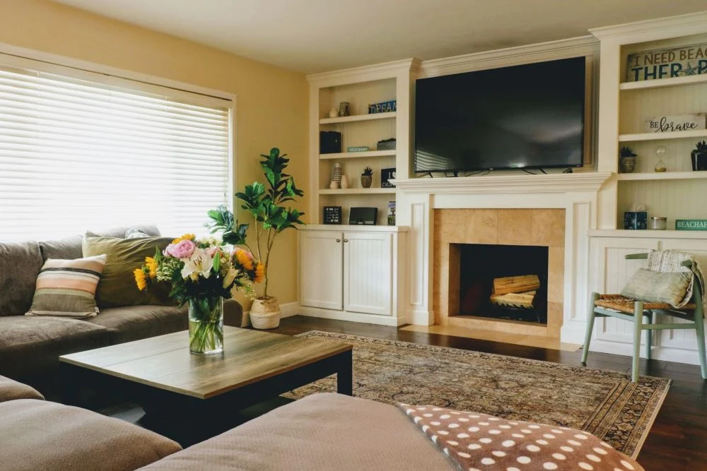 Cozy living room with fireplace, TV, and floral decor