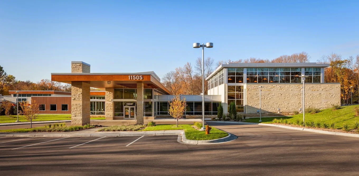 Modern treatment facility exterior with covered entrance, stone walls, and landscaped grounds