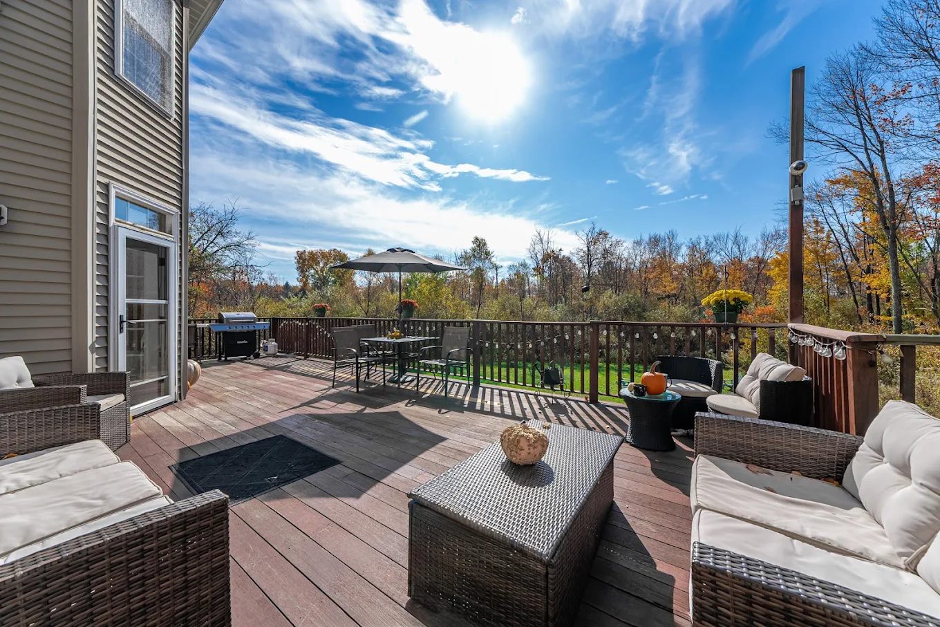 Furnished outdoor deck with sofas overlooking wooded grounds