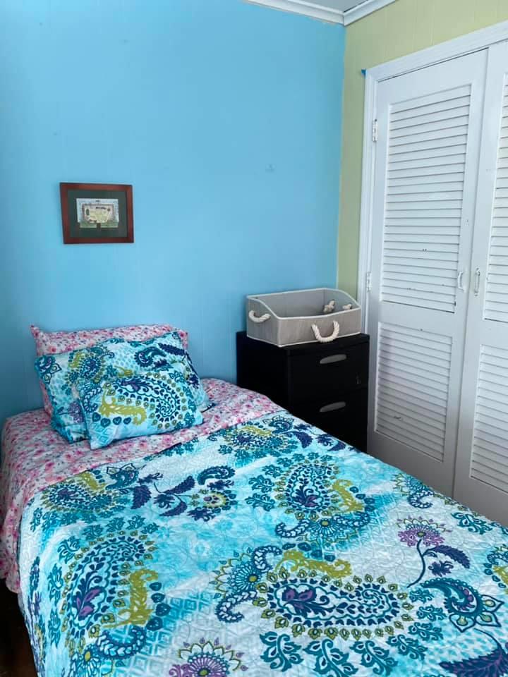 Twin bed with blue walls and patterned bedding