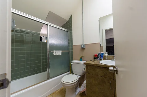 Bathroom with shower, toilet, and sink vanity