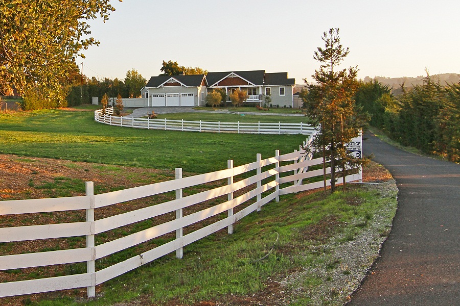 Facility driveway with a white picket fence,.