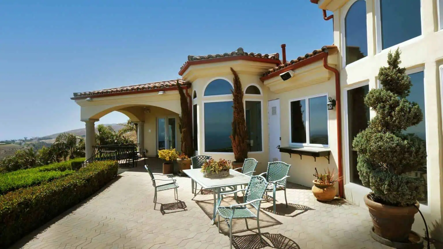 Outdoor courtyard with seating beside Mediterranean-style home