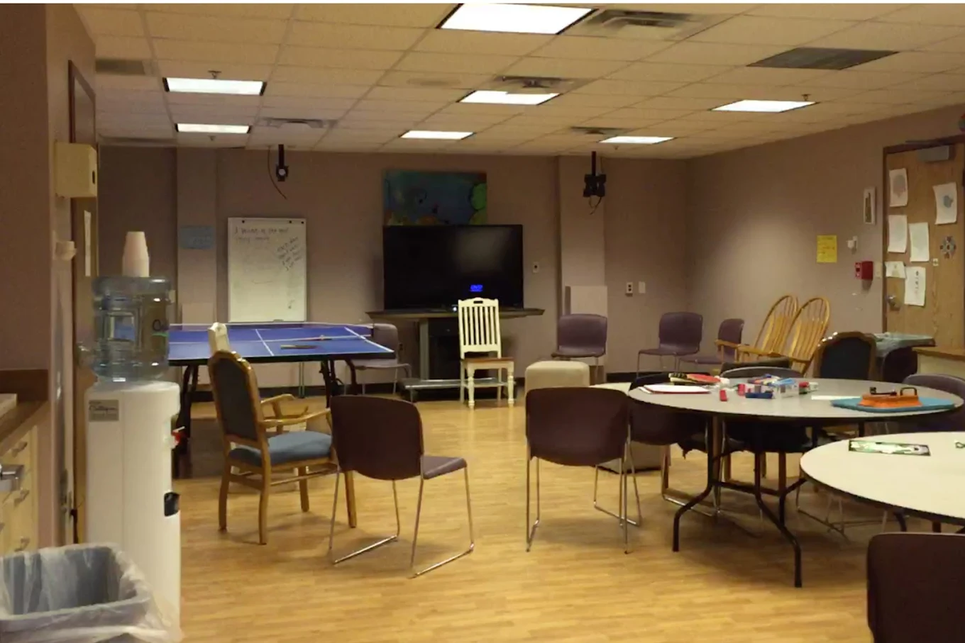 Recreational room with tables, chairs, TV, and ping pong table