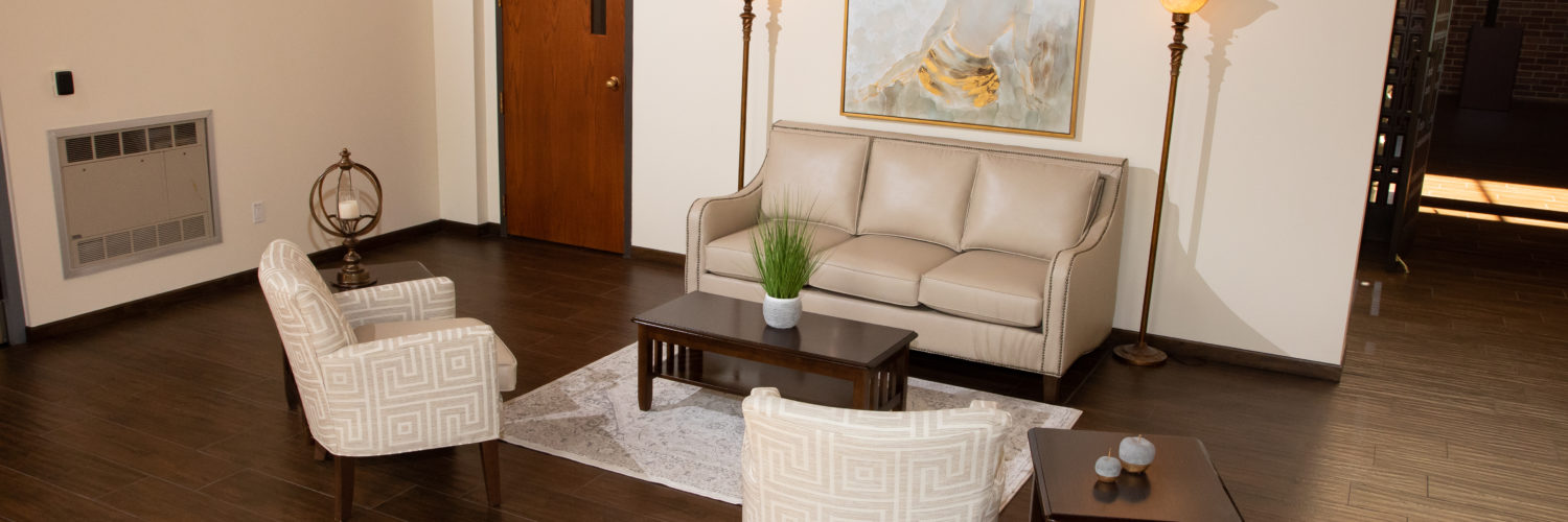 Sitting area with cream sofa, chairs, and warm lighting