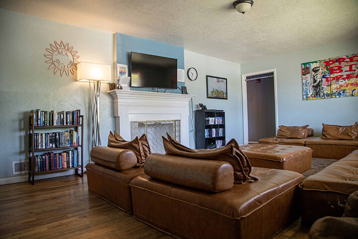 Living room with brown leather sofas, fireplace, and television