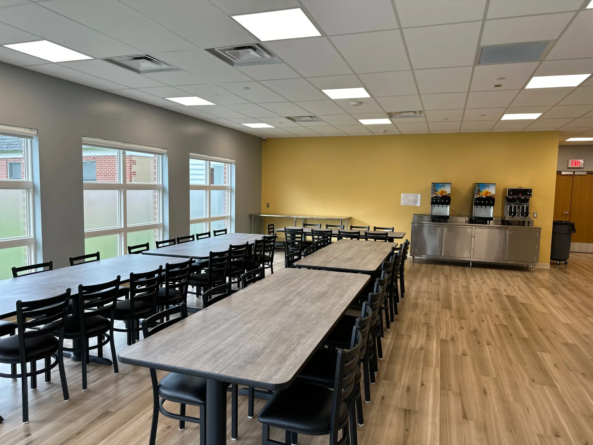 Dining hall with communal tables and beverage station.