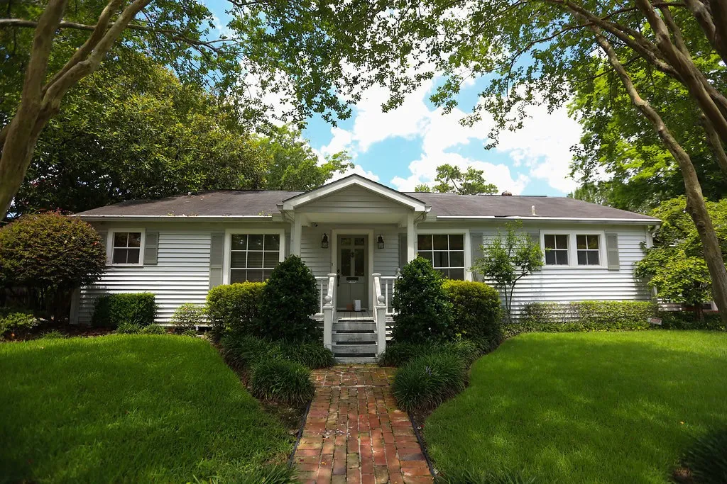 White cottage-style facility with lush landscaping