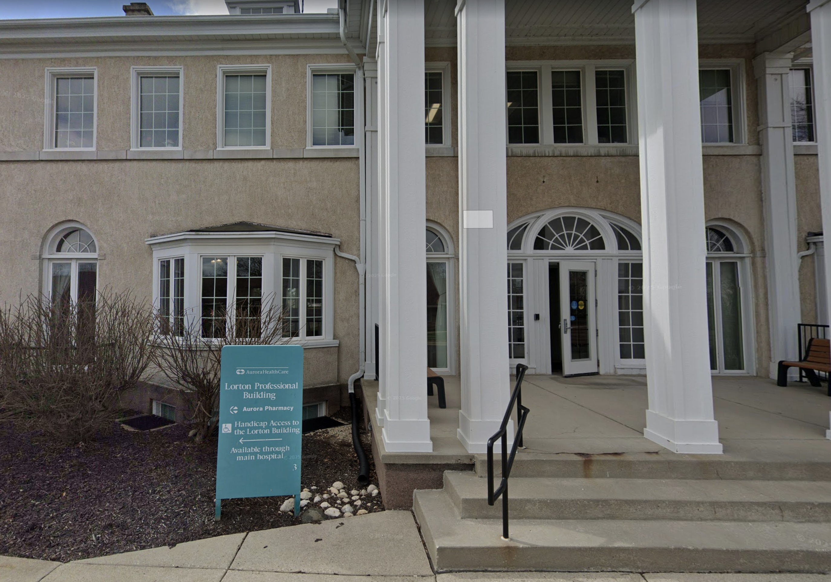 Hospital entrance with tall white columns and glass doors