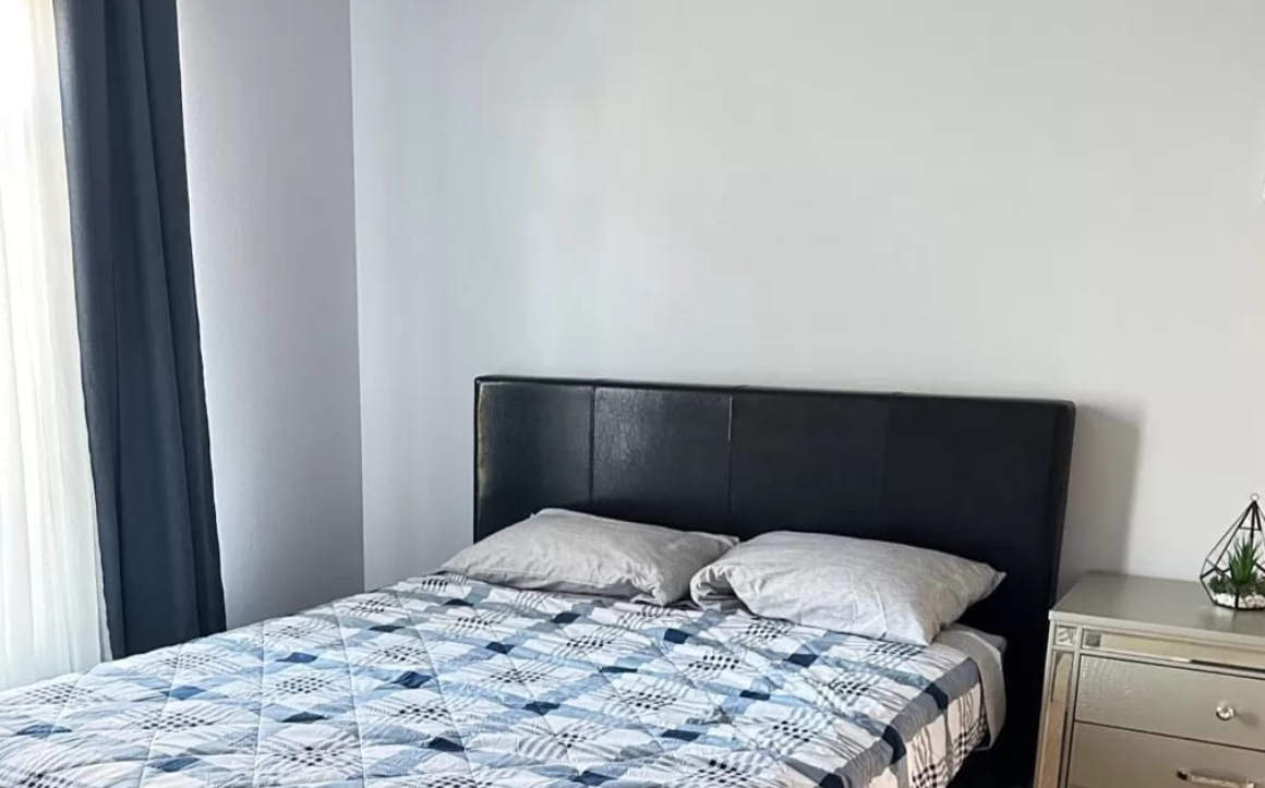 Simple bedroom with black headboard and geometric bedspread