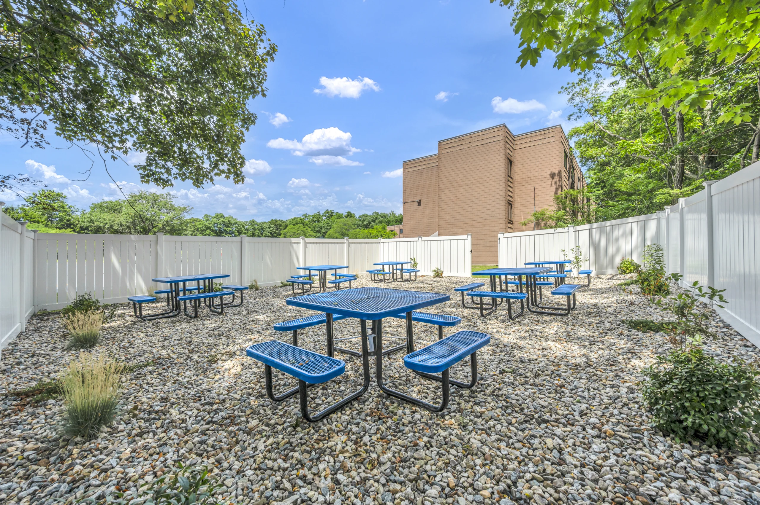 Outdoor space with blue picnic tables and white privacy fence at Boca Recovery Center Massachusetts