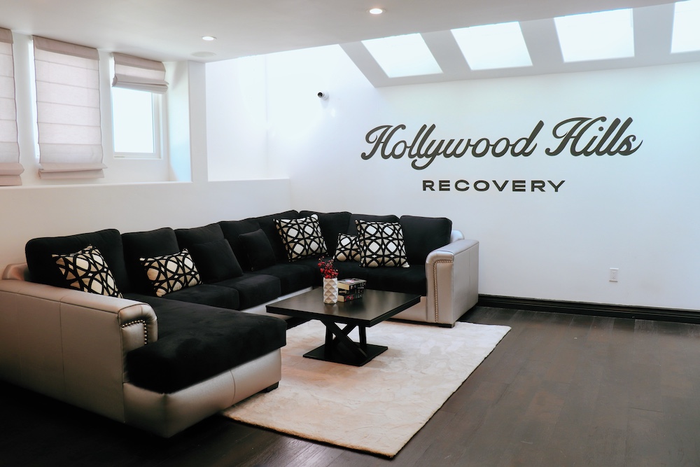 Living room with sectional couch and Hollywood Hills Recovery sign
