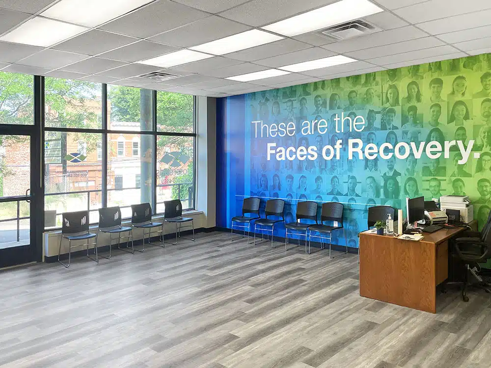 Waiting room with chairs and reception desk by large windows