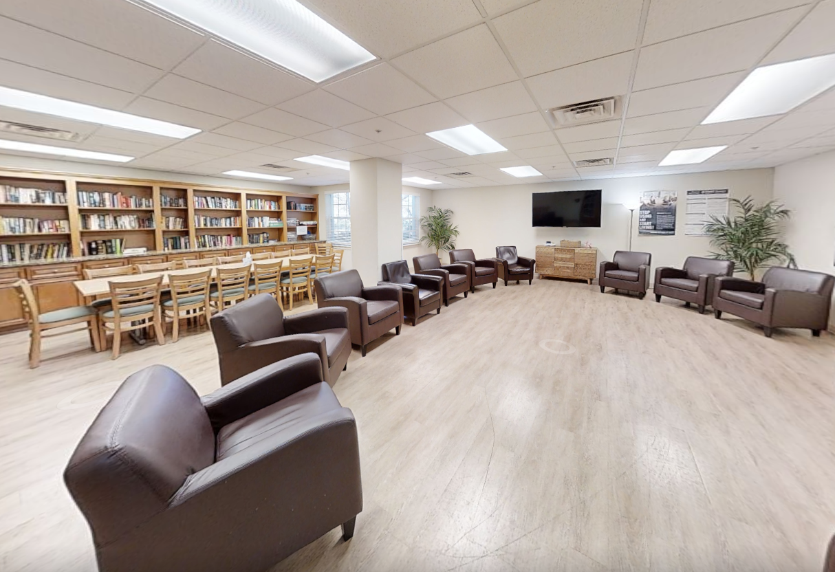 Library with bookshelves and brown leather chairs in a circle