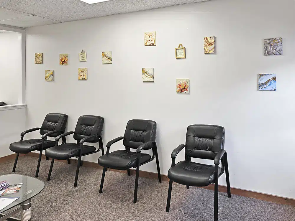 Row of chairs along wall with decorative artwork above
