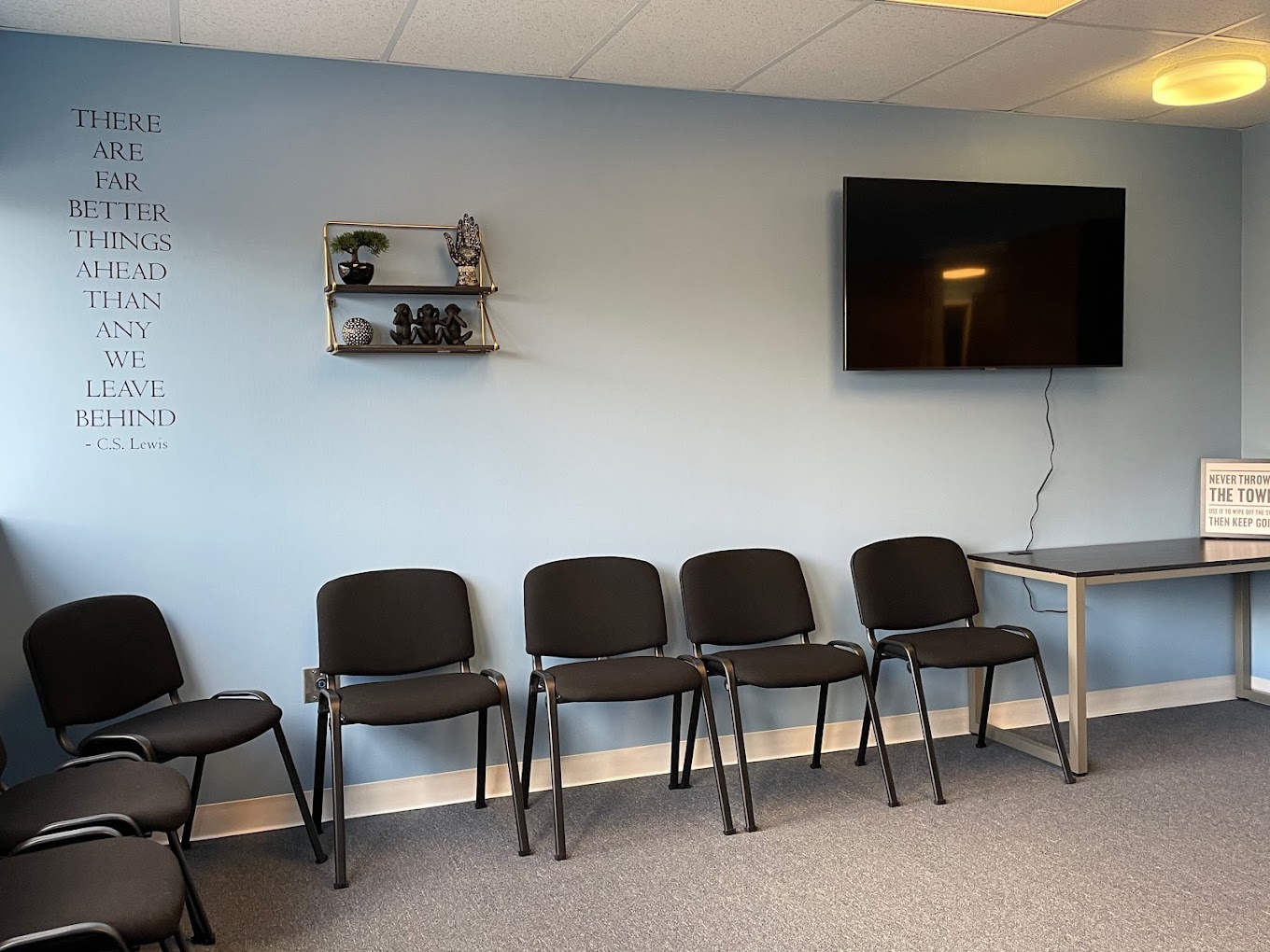 Group therapy room with black chairs and blue walls.