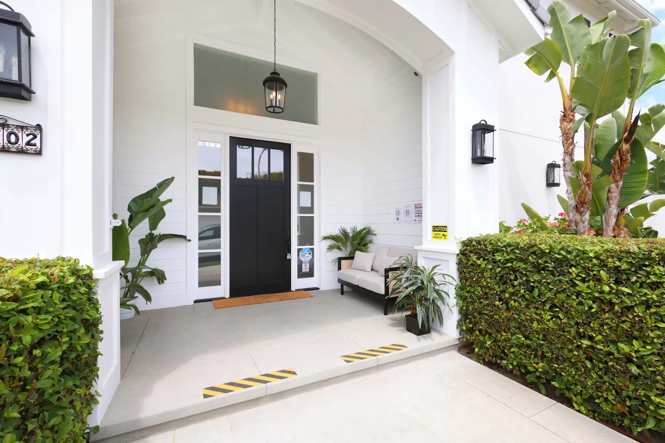 Covered facility entrance surrounded by tropical plants